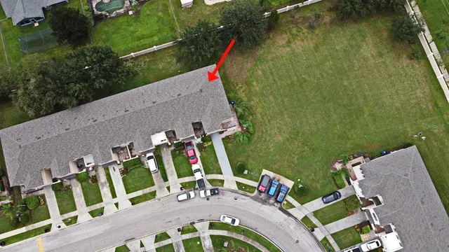 an aerial view of a house with swimming pool and outdoor seating