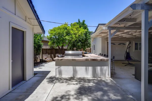 a view of a patio with table and chairs potted plants with wooden floor and fence