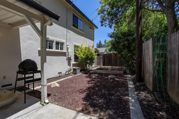 a view of a chair and table in backyard of the house