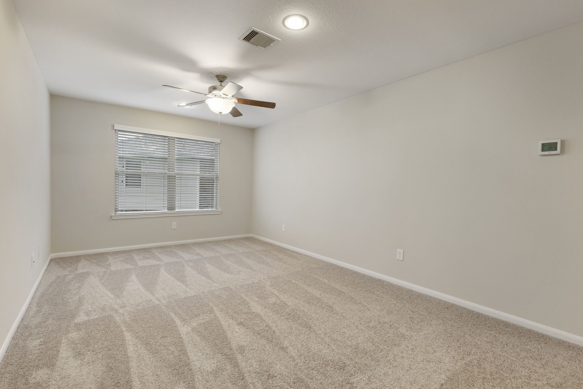 7130 Edwanna Lane Spring, TX 77389 - Photo 16 of 36 This large and bright gameroom features neutral walls and brand new carpet. It features a ceiling fan and a large window for natural light, creating a welcoming atmosphere.