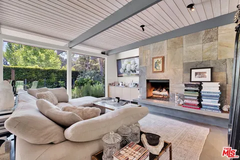 a living room with furniture fireplace and a large window
