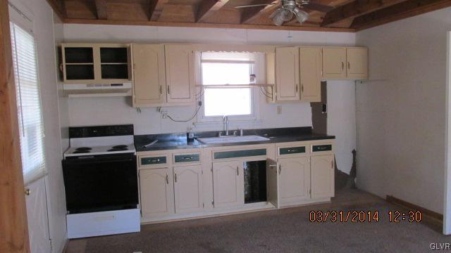 1163 Timber Hill Road Henryville, PA 18332 - Photo 8 of 8 a kitchen with a stove cabinets and a refrigerator