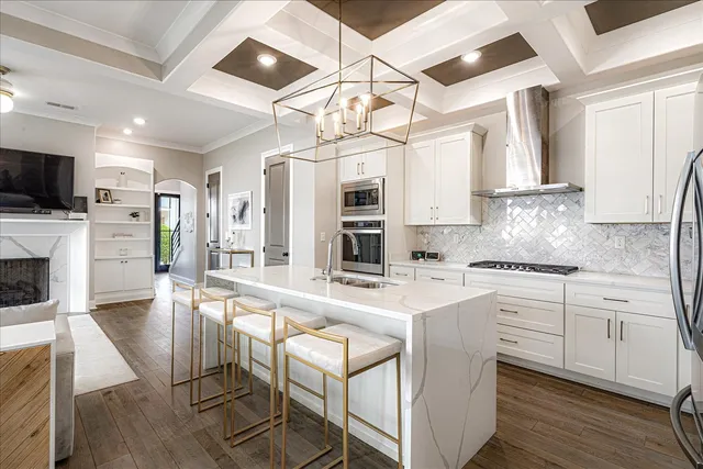 a kitchen with stainless steel appliances granite countertop a stove refrigerator and cabinets with wooden floor