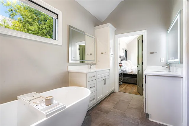 a bathroom with a tub sink and mirror