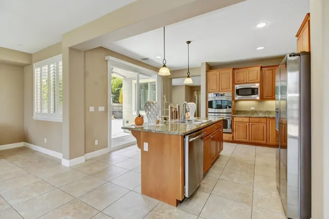 a kitchen with stainless steel appliances granite countertop a sink and a refrigerator