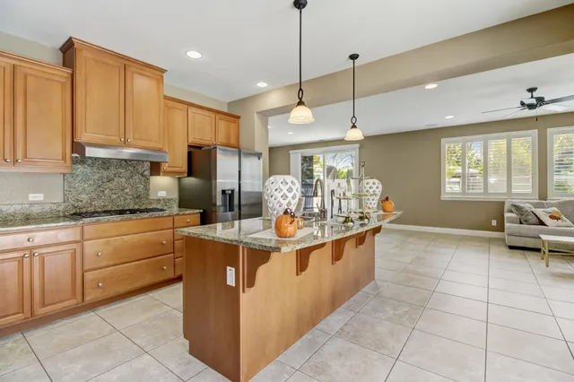 a kitchen with granite countertop a stove a refrigerator and cabinets