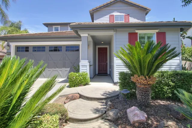 a view of a house with a yard plants and a table