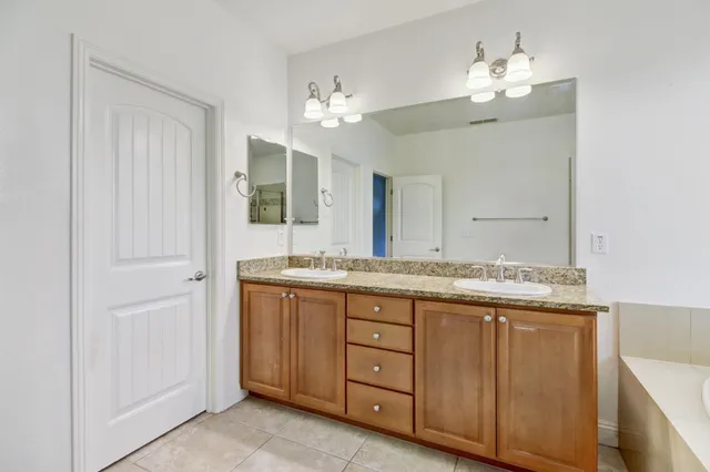 a bathroom with a granite countertop toilet sink and mirror