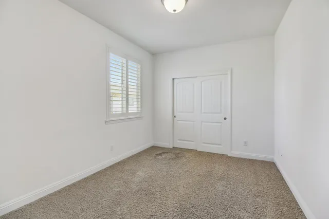 an empty room with closet and a bathroom