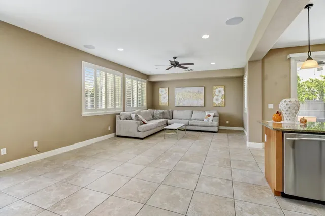 a living room with couches and kitchen view with wooden floor