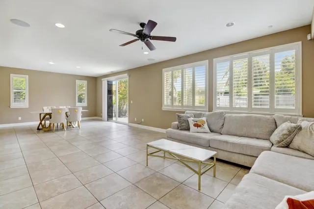 a dining room with furniture and large windows