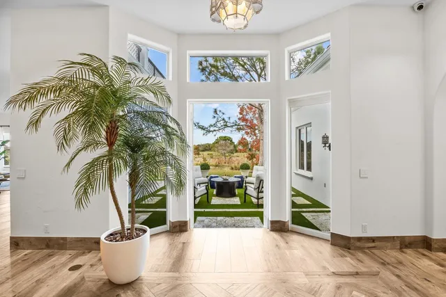 a dining room with furniture a chandelier and wooden floor