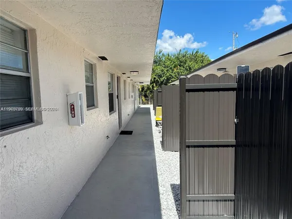 a view of a house with backyard and wooden fence