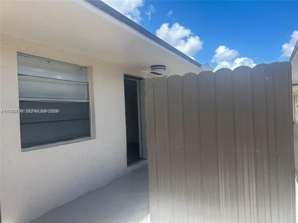 a view of a entryway door with chandelier fan