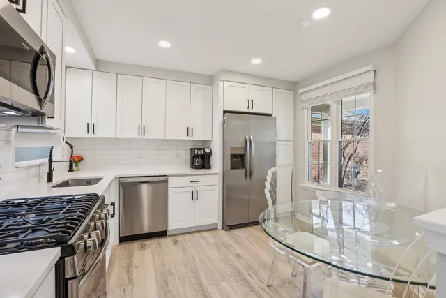 a kitchen with stainless steel appliances granite countertop a stove a sink and a refrigerator