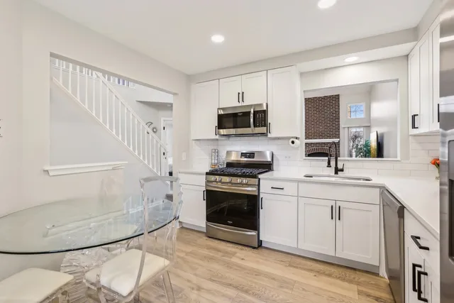 a kitchen with stainless steel appliances a stove a sink and a microwave