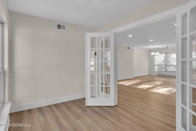 a view of empty room with wooden floor