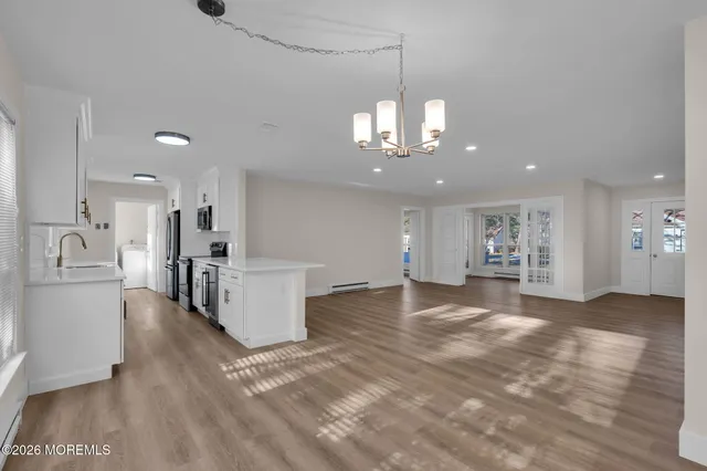 a view of a big room with windows and a chandelier