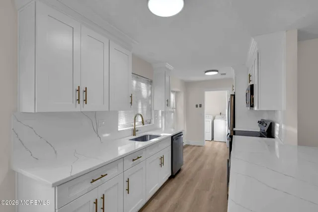 a large white kitchen with stainless steel appliances