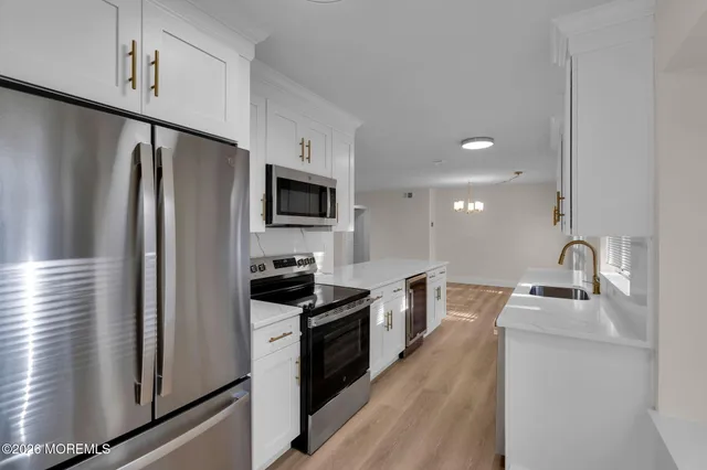 a kitchen with stainless steel appliances a refrigerator sink and microwave
