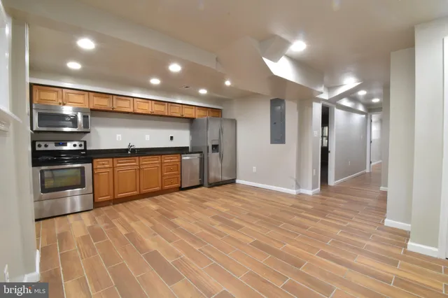 a large kitchen with stainless steel appliances granite countertop a stove and a sink