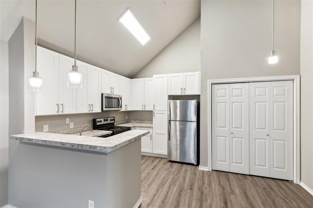 6108 Abrams Road, Unit 530 Dallas, TX 75231 - Photo 1 of 19 a kitchen with refrigerator a sink and white cabinets