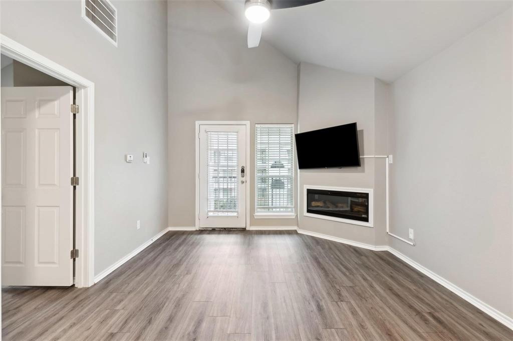 6108 Abrams Road, Unit 530 Dallas, TX 75231 - Photo 3 of 19 a view of a livingroom with a flat screen tv wooden floor and a fireplace