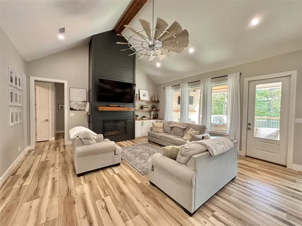 a living room with furniture a flat screen tv and a fireplace