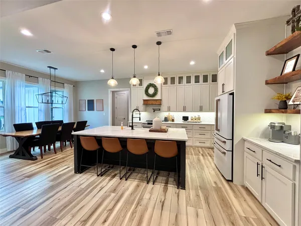 a large kitchen with a table and chairs