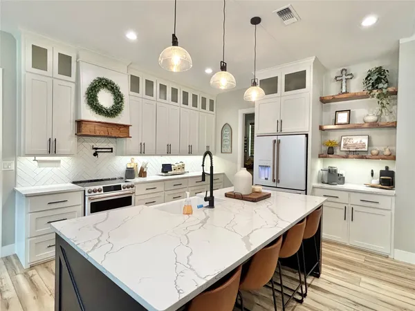 a kitchen with a white center island and cabinets