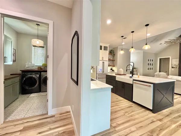 a view of a kitchen with kitchen island a sink wooden floor and living room view