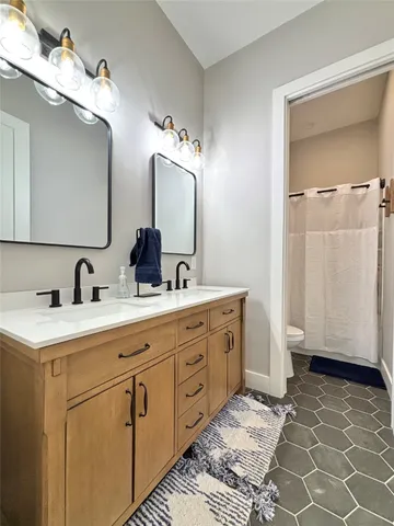a bathroom with a double vanity sink a mirror and a shower