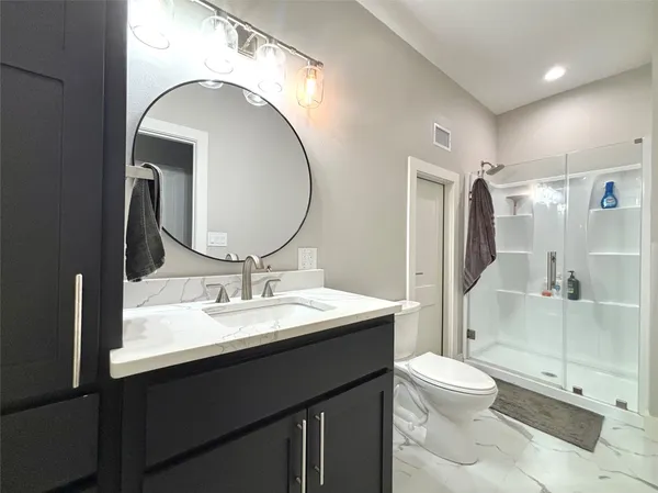 a bathroom with a toilet sink and mirror