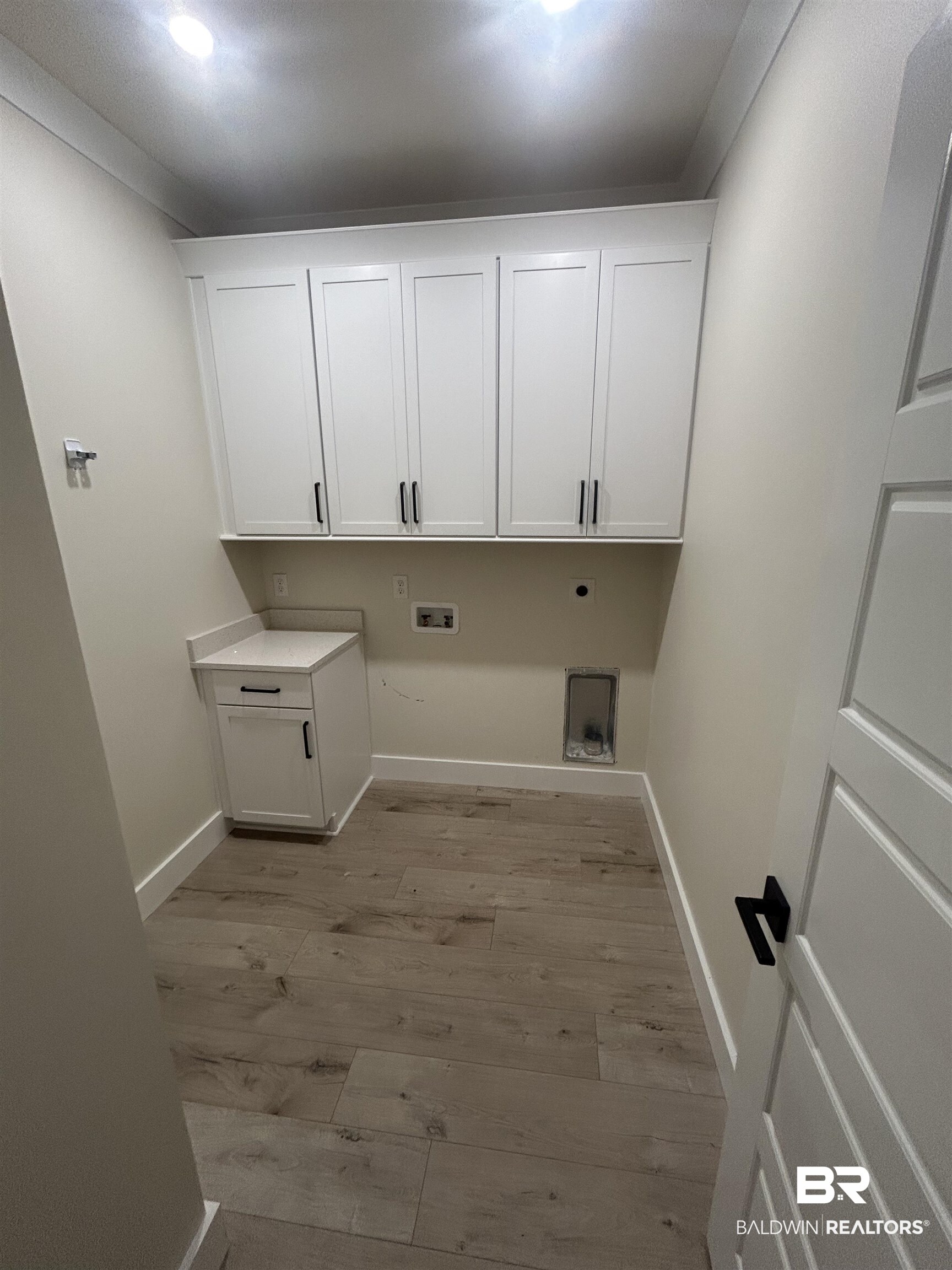 5122 Pine Road Orange Beach, AL 36561 - Photo 23 of 24 Laundry room featuring washer hookup, electric dryer hookup, light wood-style floors, and cabinet space