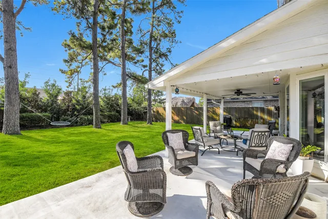 a view of a patio with couches chairs and a big yard