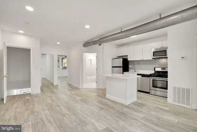a kitchen with a refrigerator and a stove top oven