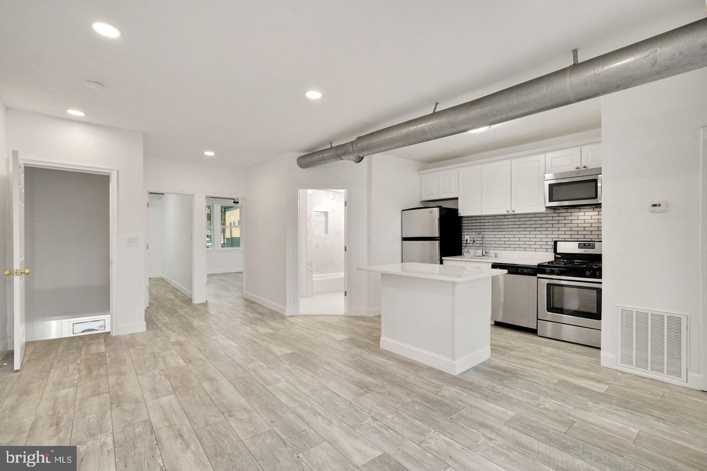 a kitchen with a refrigerator and a stove top oven
