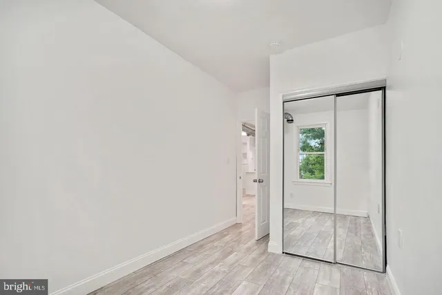 an empty room with wooden floor and sliding door