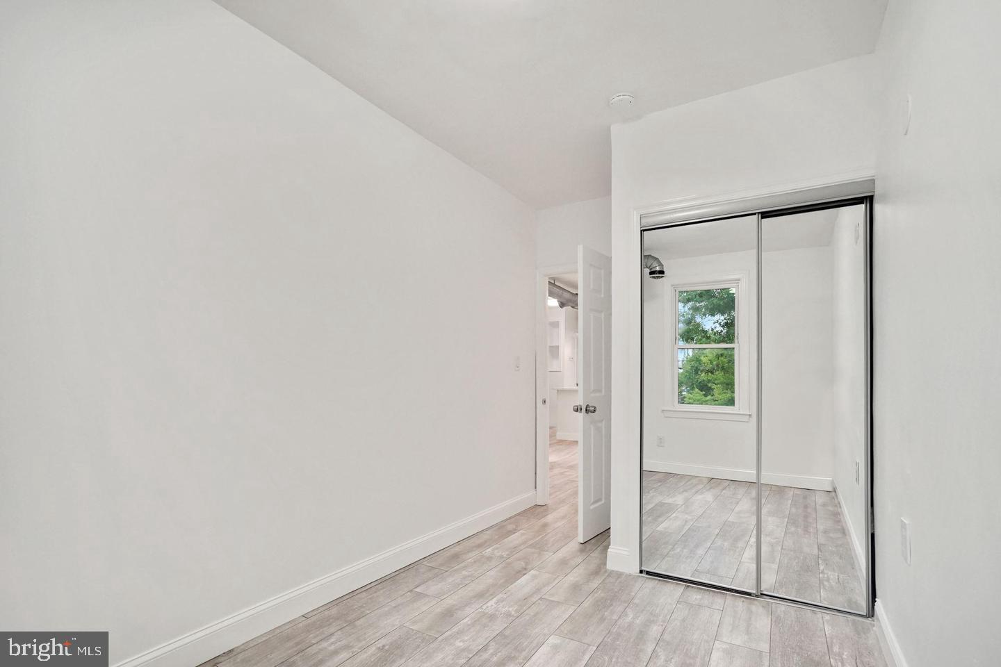 5413 Georgia Avenue Northwest Washington, DC 20011 - Photo 14 of 22 an empty room with wooden floor and sliding door