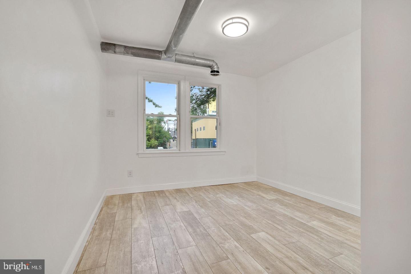 5413 Georgia Avenue Northwest Washington, DC 20011 - Photo 6 of 22 an empty room with wooden floor and windows