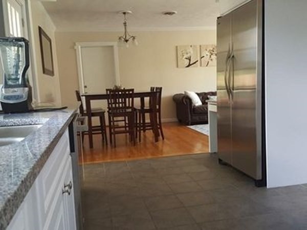 102 Harrow Road Springfield, MA 01118 - Photo 5 of 35 a kitchen with stainless steel appliances granite countertop a refrigerator a stove and a dining table with wooden floor