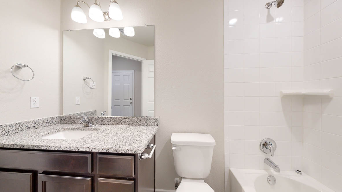 104 Kenzie Street Thorndale, TX 76577 - Photo 26 of 28 a bathroom with a granite countertop sink a toilet and a mirror
