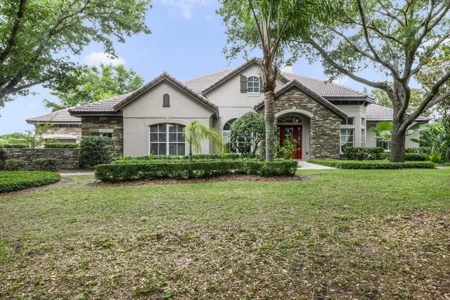 a front view of a house with a yard and trees