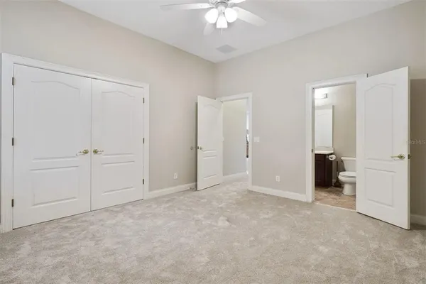 a spacious bedroom with furniture and a window