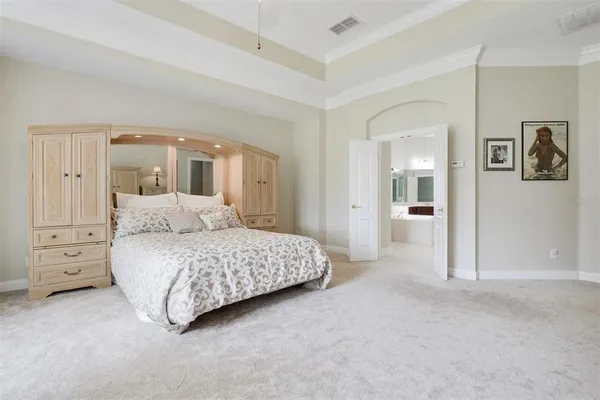 a spacious bedroom with a bed and a chandelier
