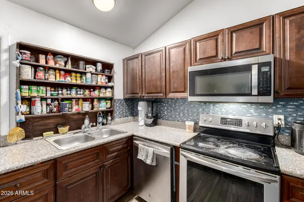 a kitchen with a sink a counter space and stainless steel appliances