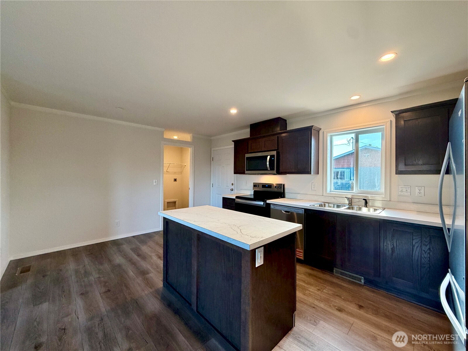 299 Octopus Avenue Northeast Ocean Shores, WA 98569 - Photo 11 of 40 a kitchen with a sink and wooden floor