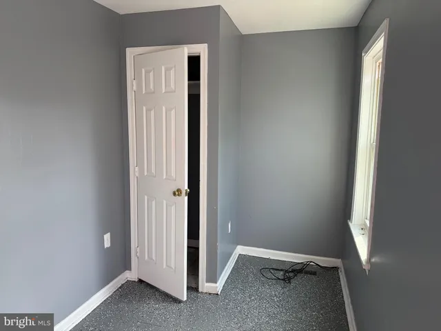 an empty room with windows and closet