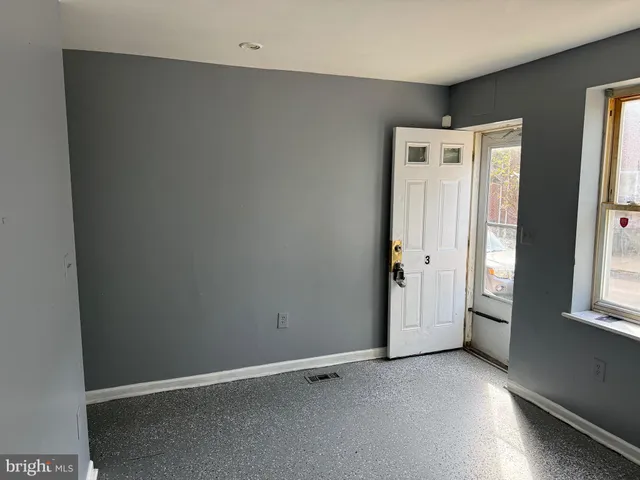 an empty room with windows and cabinet