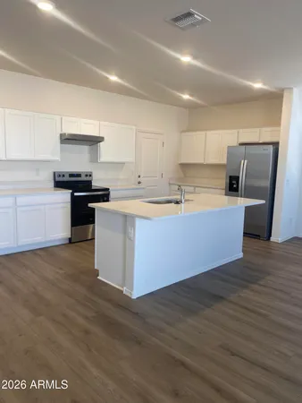 a kitchen with stainless steel appliances granite countertop a sink stove and refrigerator